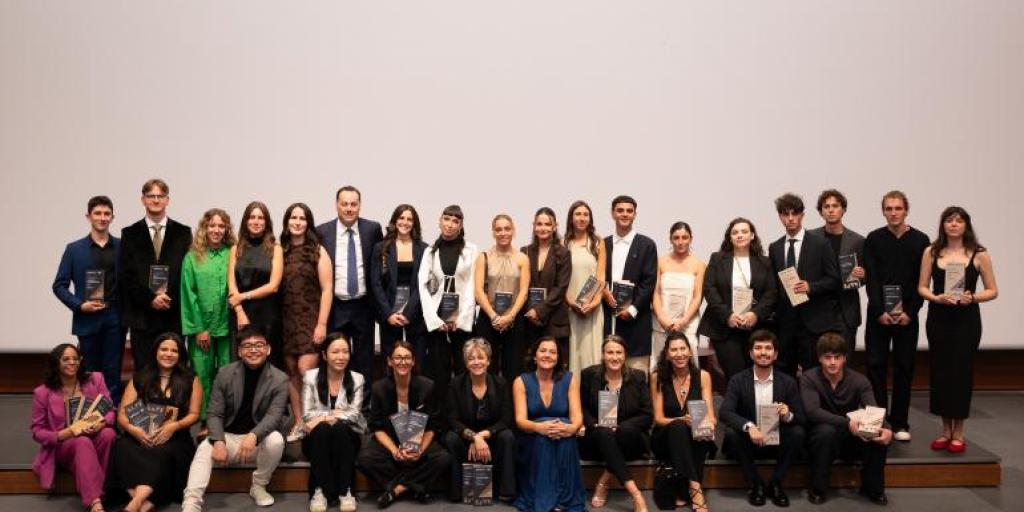 Gruppo di persone disposte su due file che posano vestite elegantemente